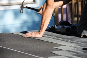 worker working on repairing the damaged roof